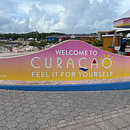 Schriftzug "Welcome to Curacao" an einer Steinmauer